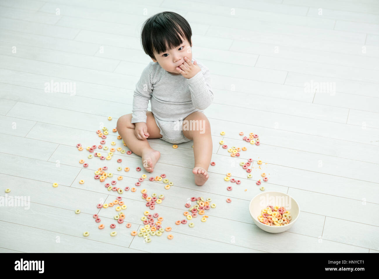 Baby boy making mess with cereal Stock Photo - Alamy