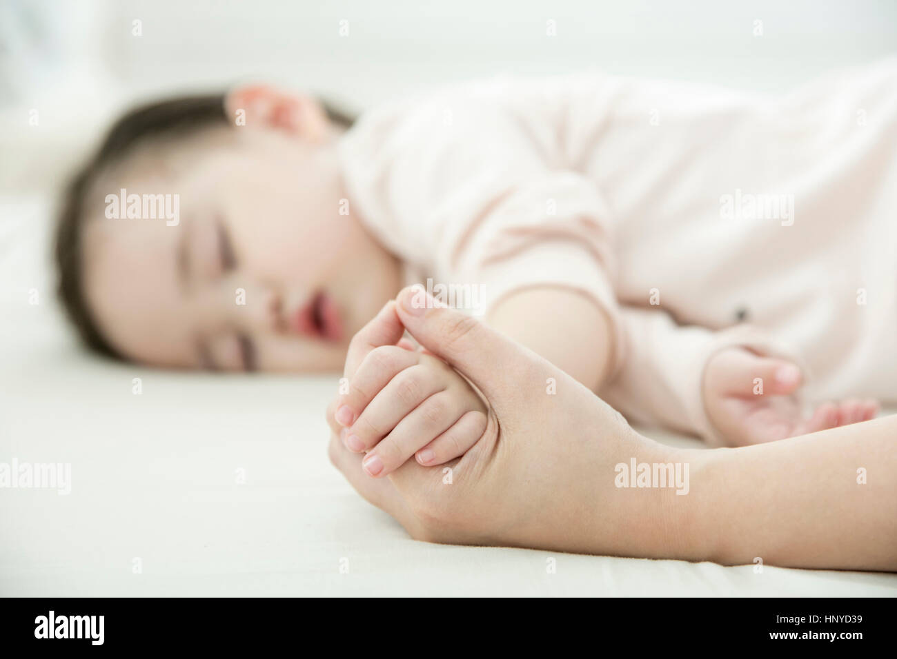 Hand holding sleeping baby's hand Stock Photo