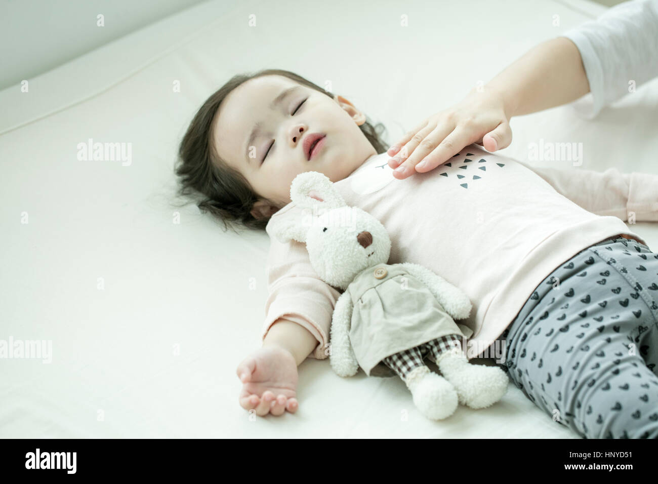 Hand touching sleeping baby's belly Stock Photo