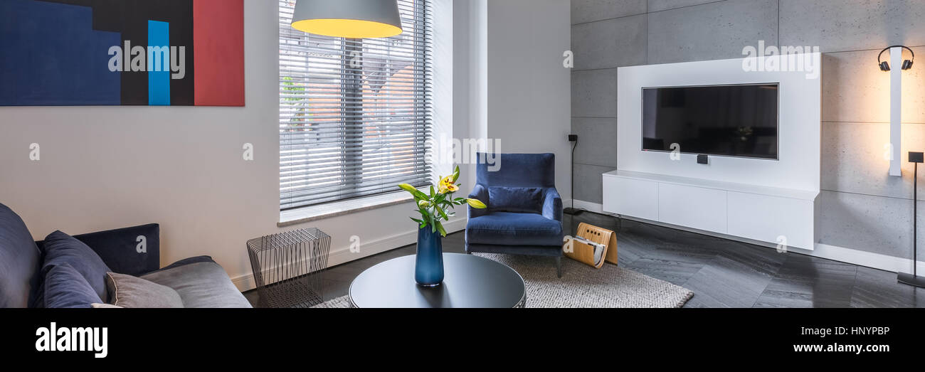 Panoramic photo of living room with stylish armchair and coffee table ...