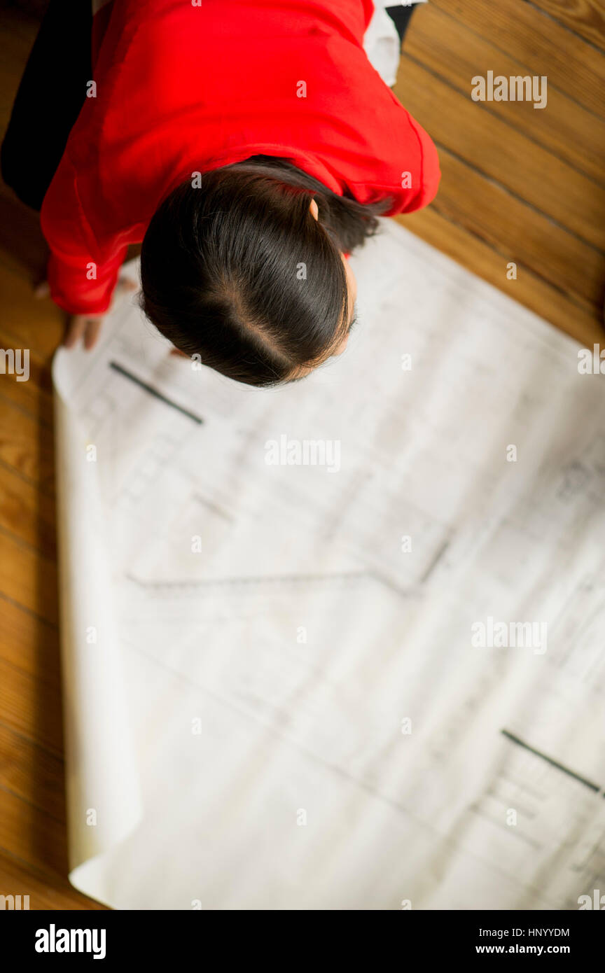 Female architect looking at blueprint Stock Photo - Alamy