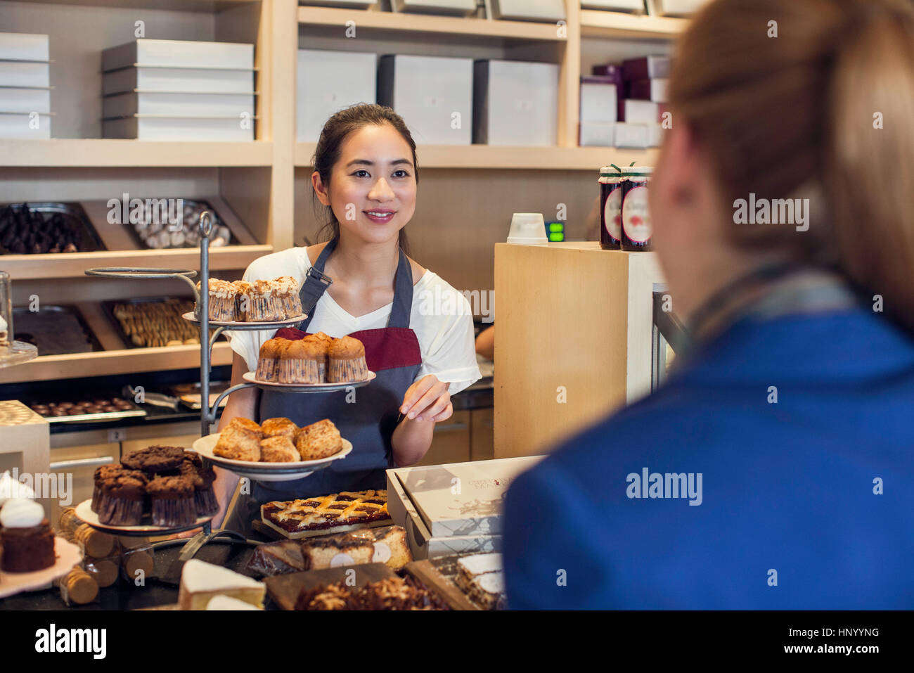 Young woman assisting customer in bakery Stock Photo