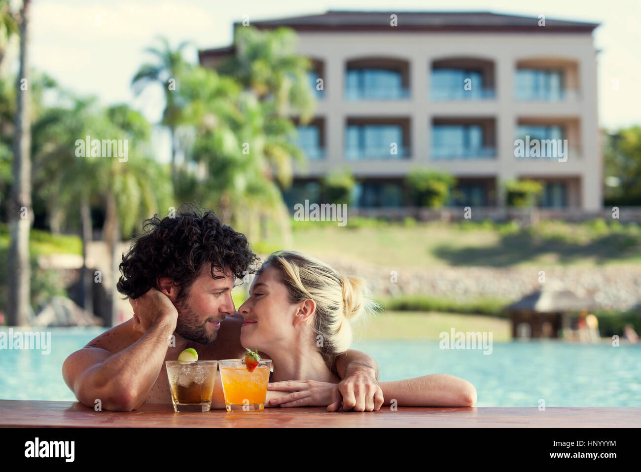 Couple relaxing together in resort pool Stock Photo