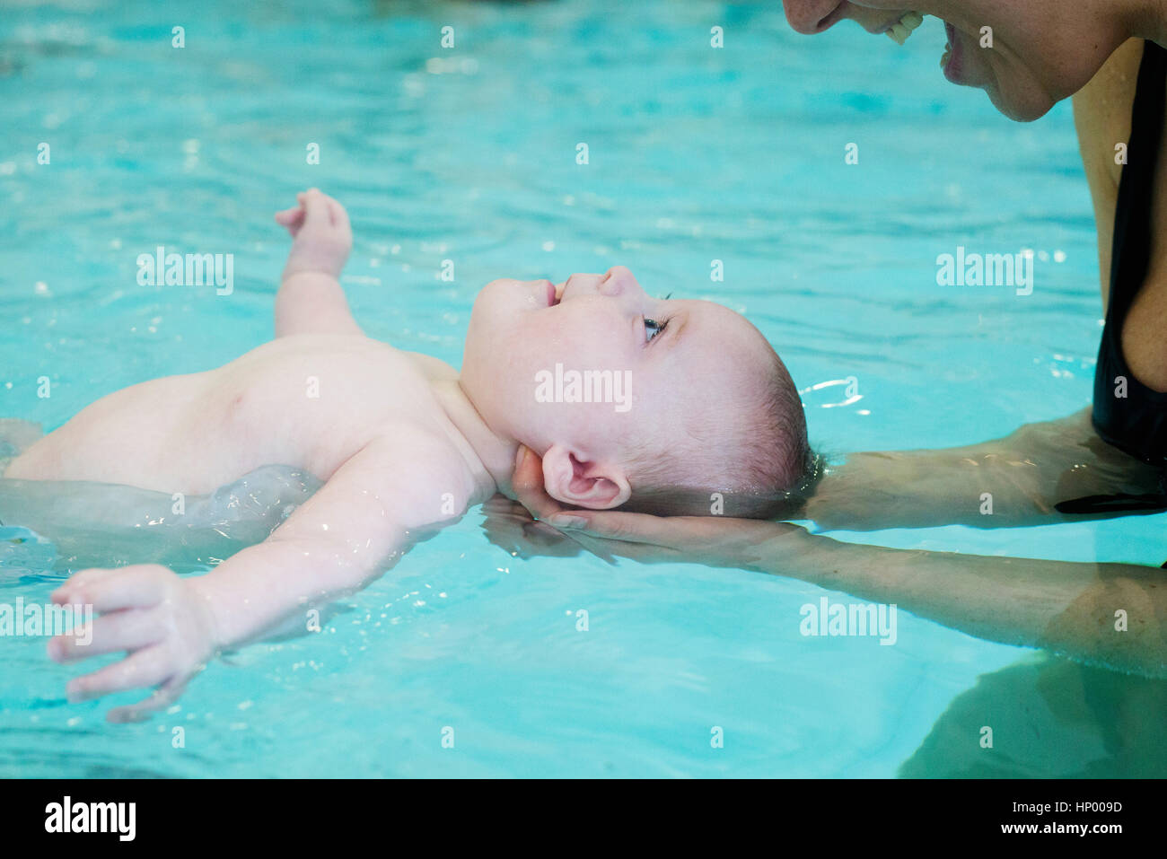 Mother teaching infant how to float in swimming pool Stock Photo Alamy