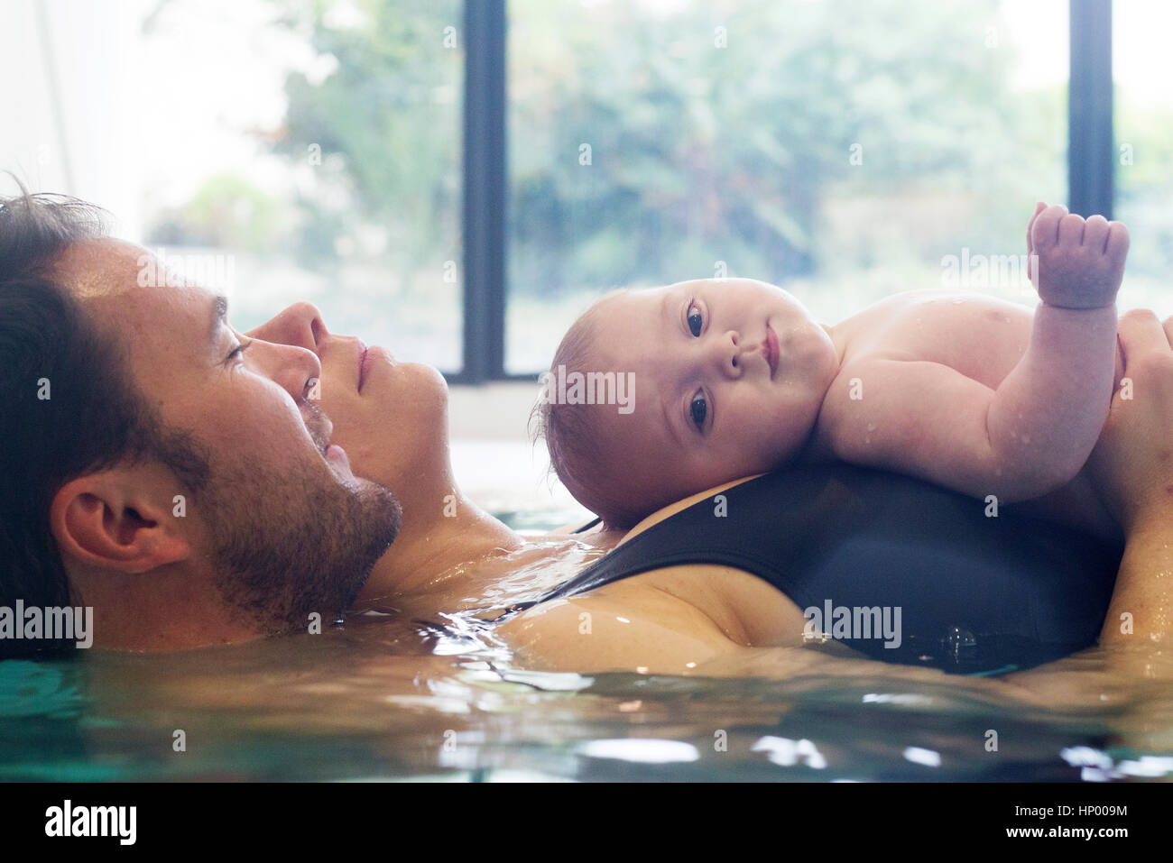 Parents with infant in swimming pool Stock Photo Alamy