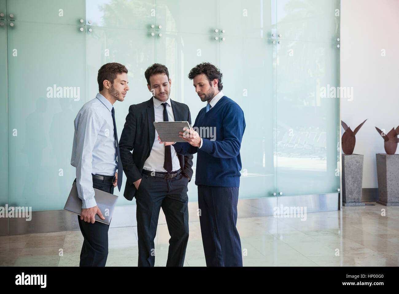 Businessman presenting idea to associates using digital tablet Stock Photo