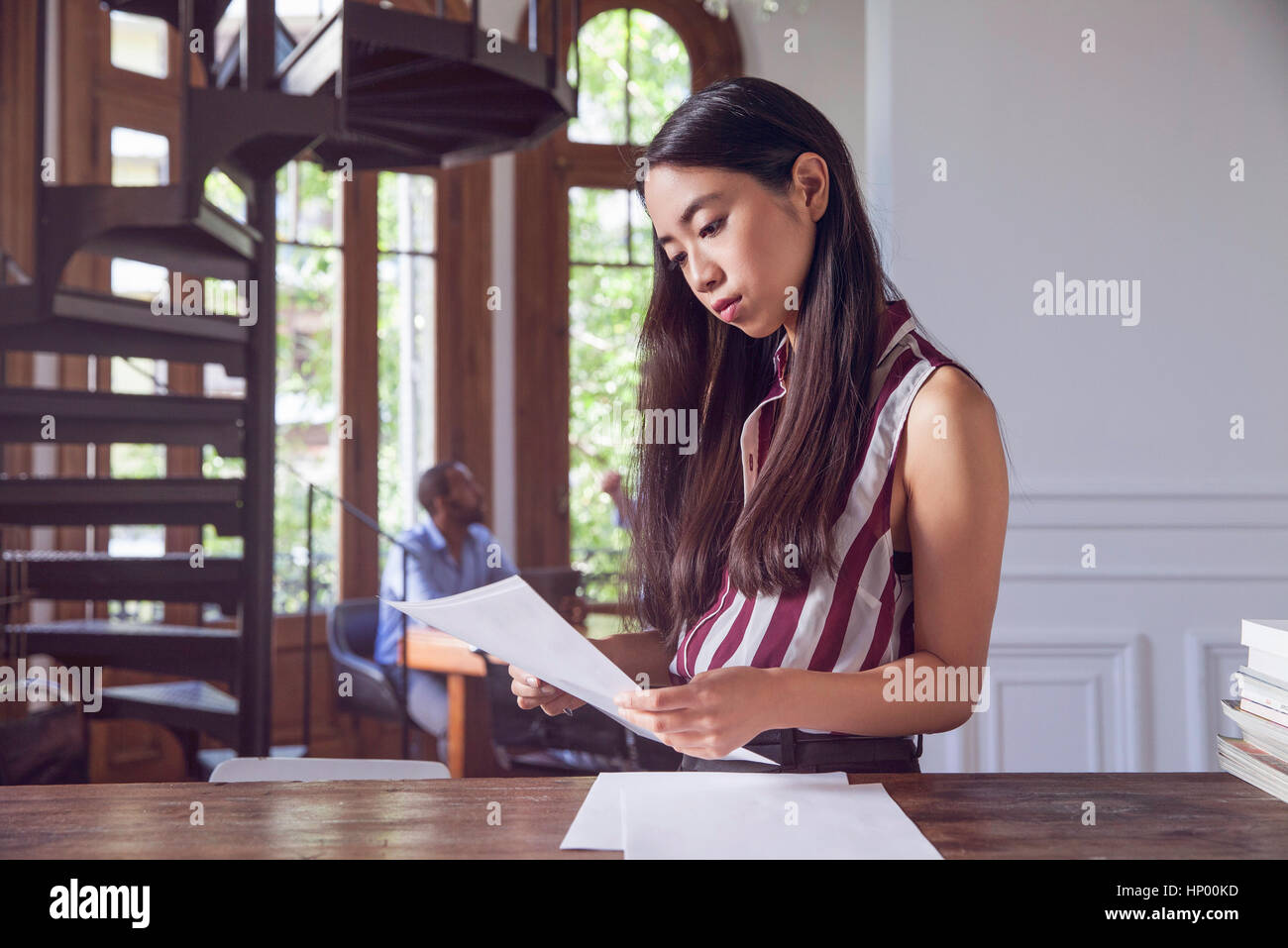 Woman reading document in office Stock Photo