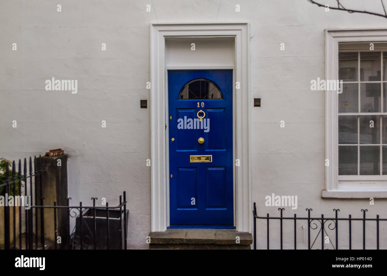 white house with a blue door with a brass knocker, tree and fence Stock ...