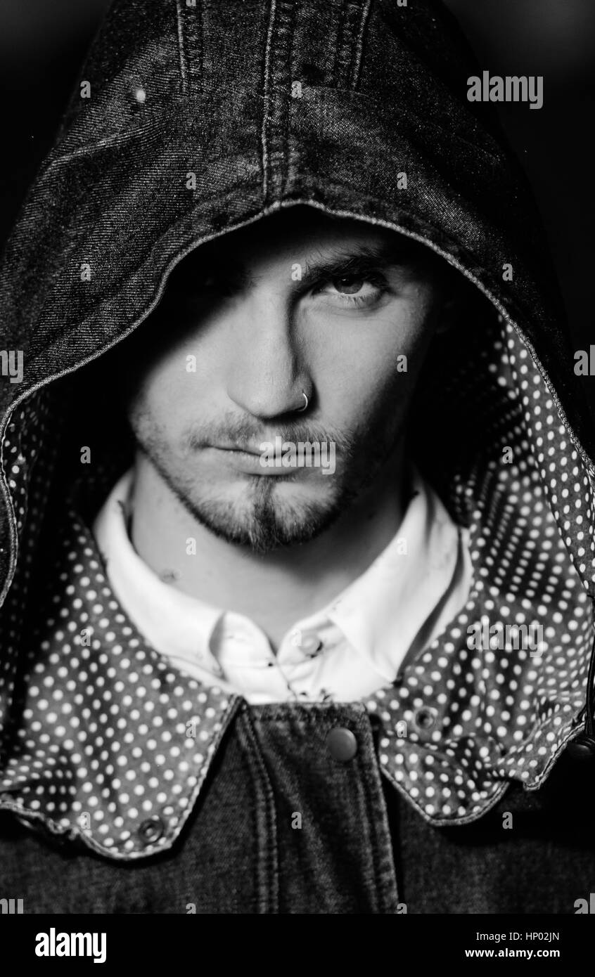 Portrait of man with hood looking at camera. Black and white portrait Stock Photo