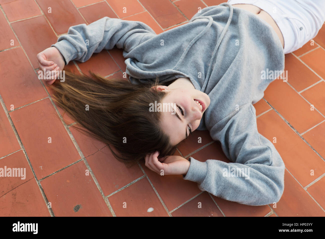 Young woman lying on laid floor. Horizontal shot with natural light ...