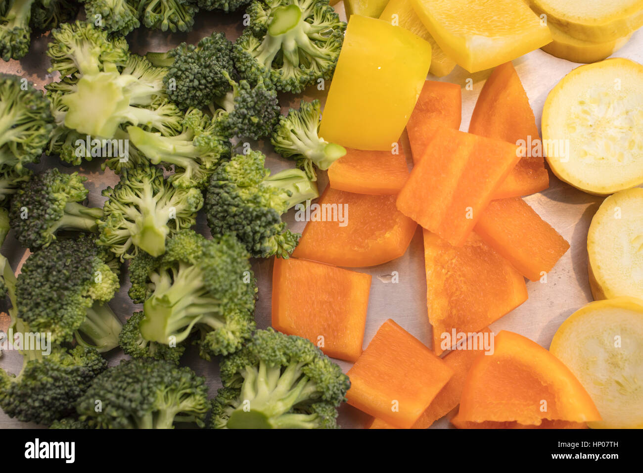 Brightly colored Cauliflower, Broccoli, Bell Peppers and Zucchini being prepared to be roasted  for a dinner meal Stock Photo