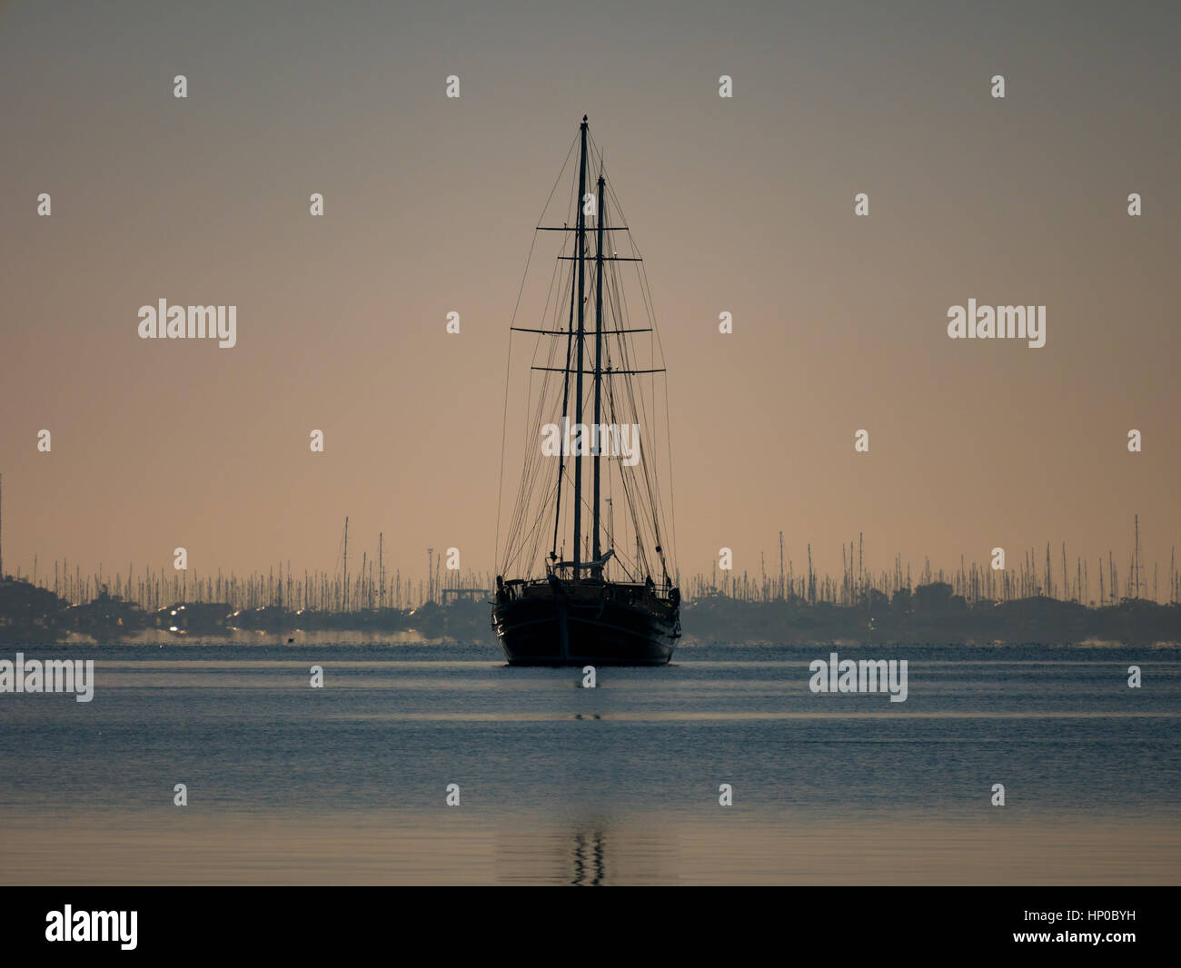 Sunset over yacht harbor with silhouettes of masts Stock Photo - Alamy
