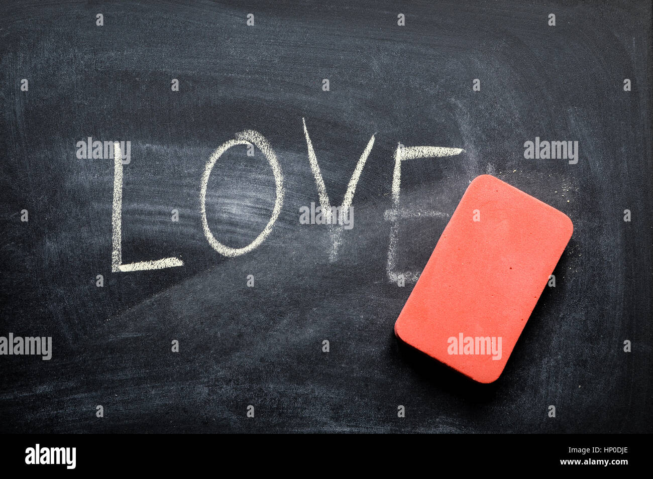 erasing love, hand written word on blackboard being erased concept Stock Photo
