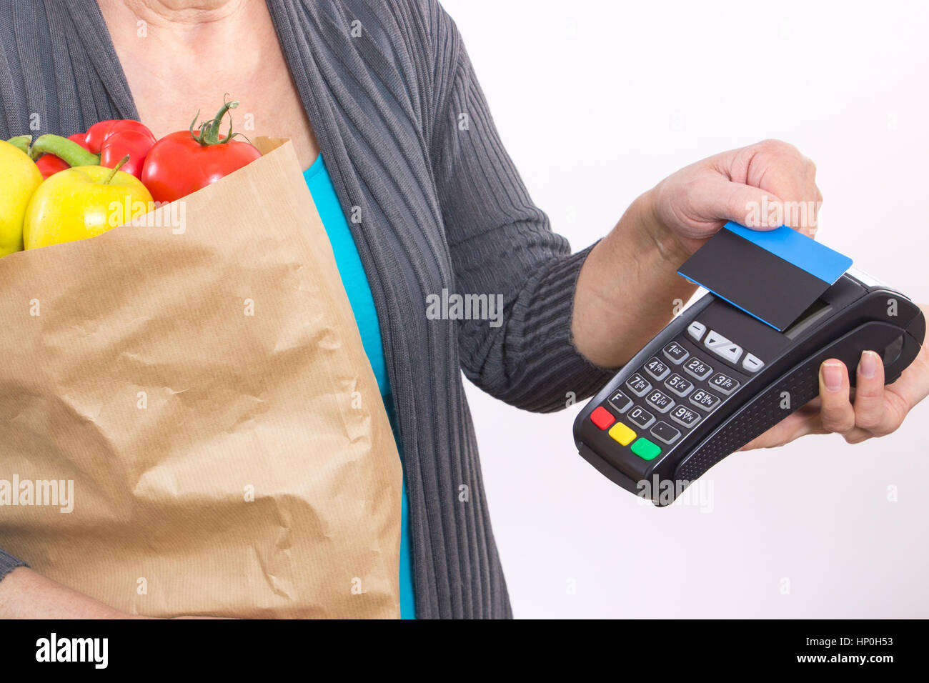 Hand of elderly senior woman using payment terminal with contactless credit card, cashless paying for shopping Stock Photo
