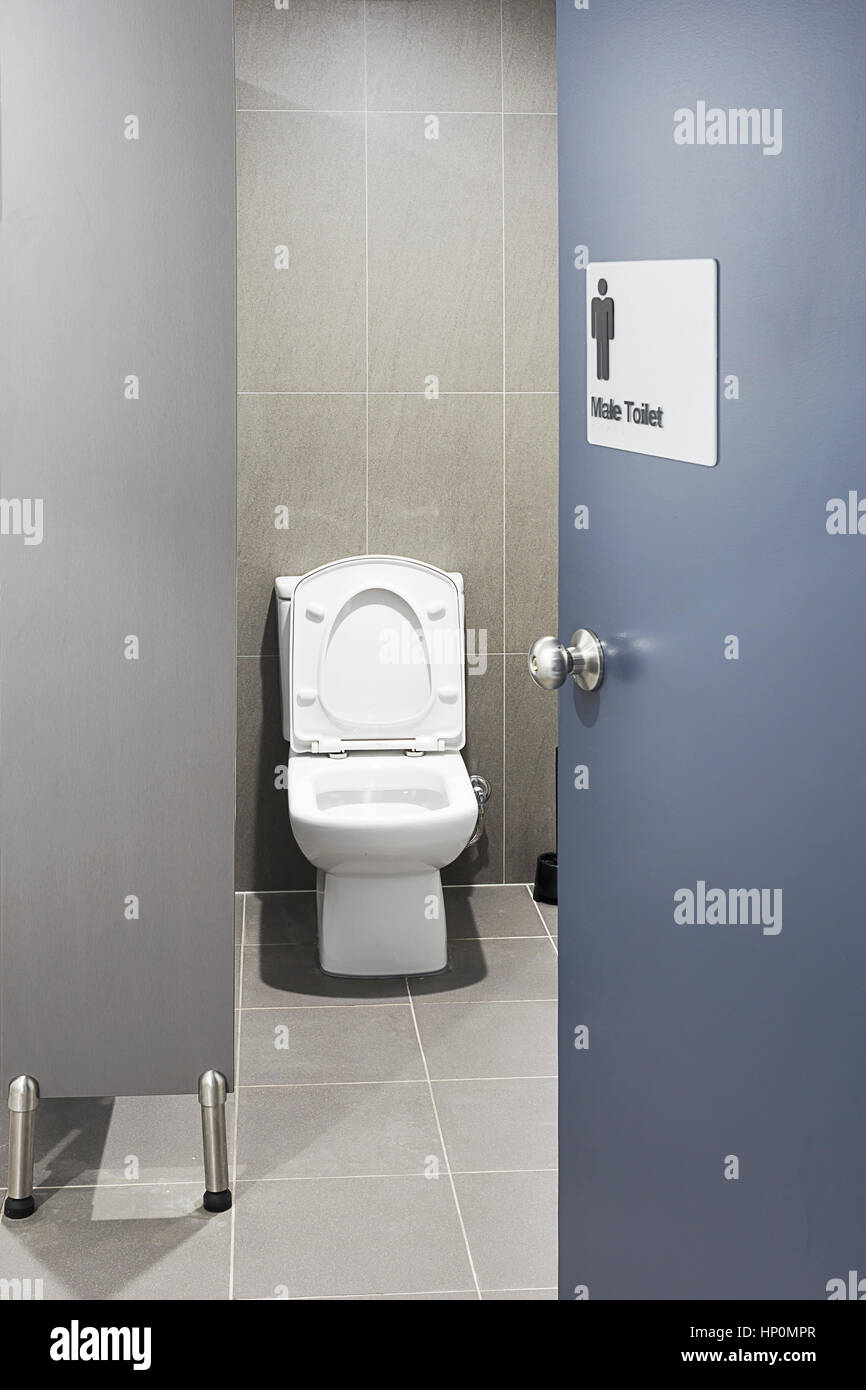 Single sanitary toilet seat in a cabin of male restroom with door adjurred freshly cleaned. Stock Photo