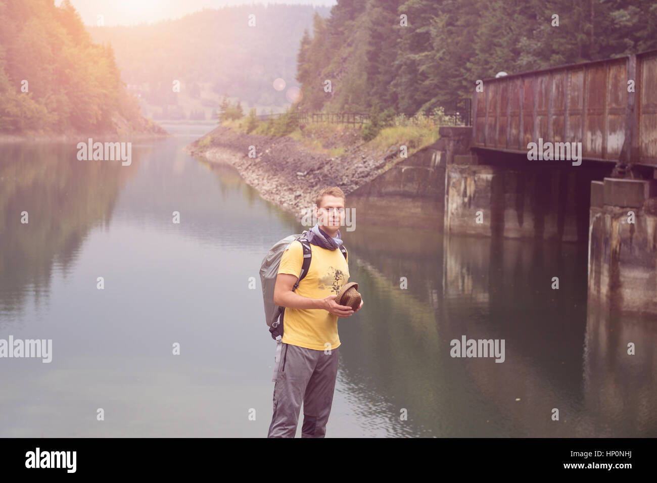 man standing under bridge across river travel concept Stock Photo