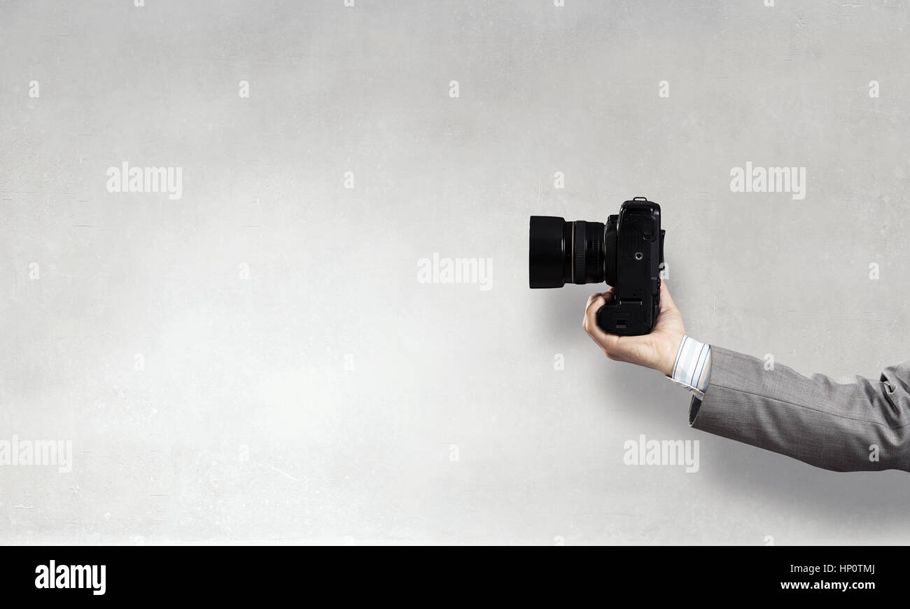 Close of man hand in checked shirt holding photocamera Stock Photo