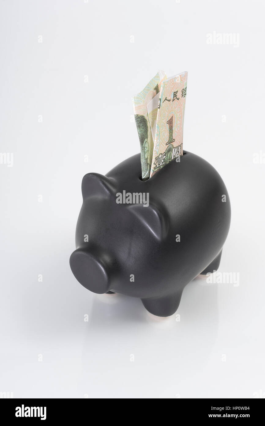 Black Piggy bank with Chinese Yuan 1 Renminbi banknote placed in coin slot. Metaphor for personal savings, or Chinese economy, China debt crisis. Stock Photo
