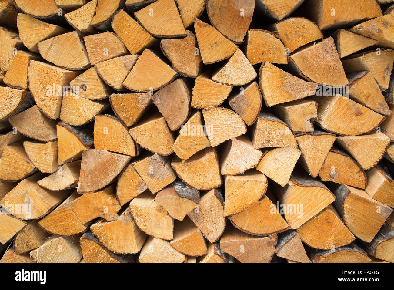 firewood - seasoned kiln-dried split logs neatly stacked background Stock Photo