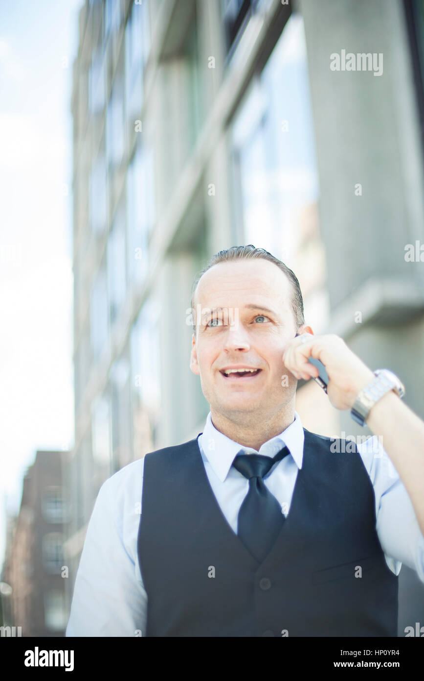 Businessman talking on cell phone outdoors Stock Photo