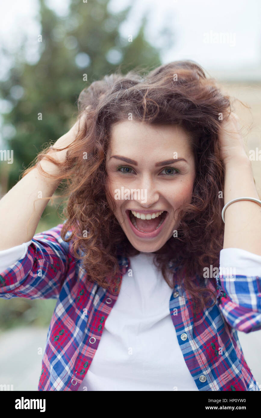 Carefree young woman laughing outdoors, portrait Stock Photo