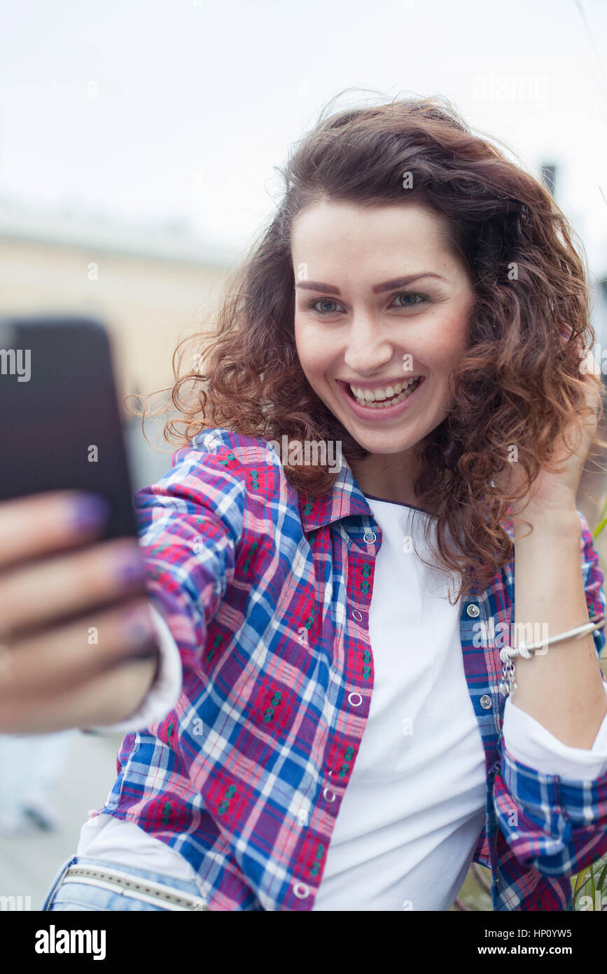 Young woman using smartphone to take a selfie Stock Photo