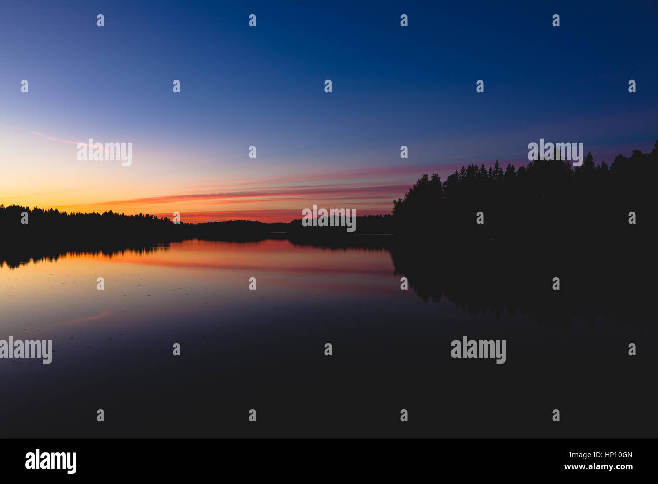 Serene view of calm lake and sunset clouds Stock Photo
