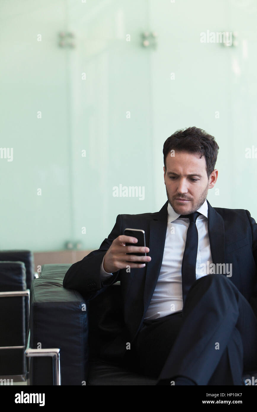 Executive looking at cell phone with concerned look Stock Photo