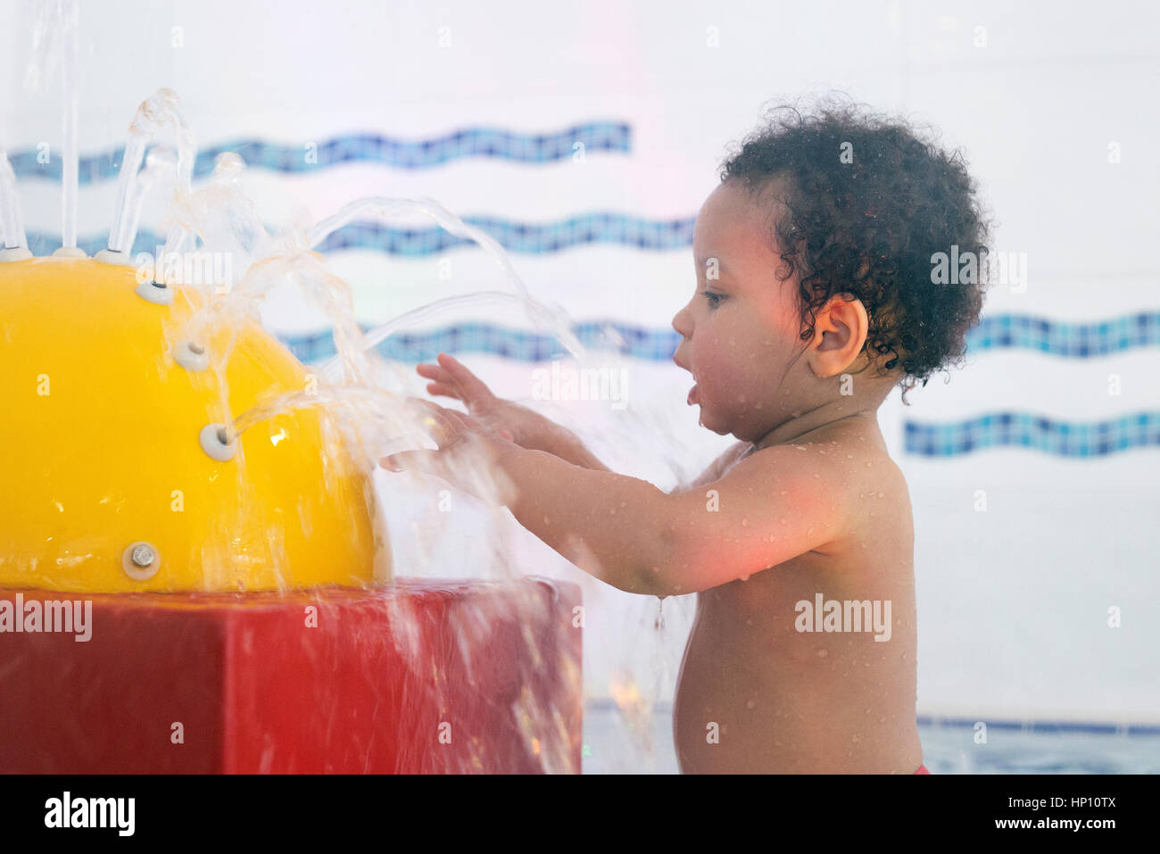 Little girl playing in fountain in wading pool Stock Photo
