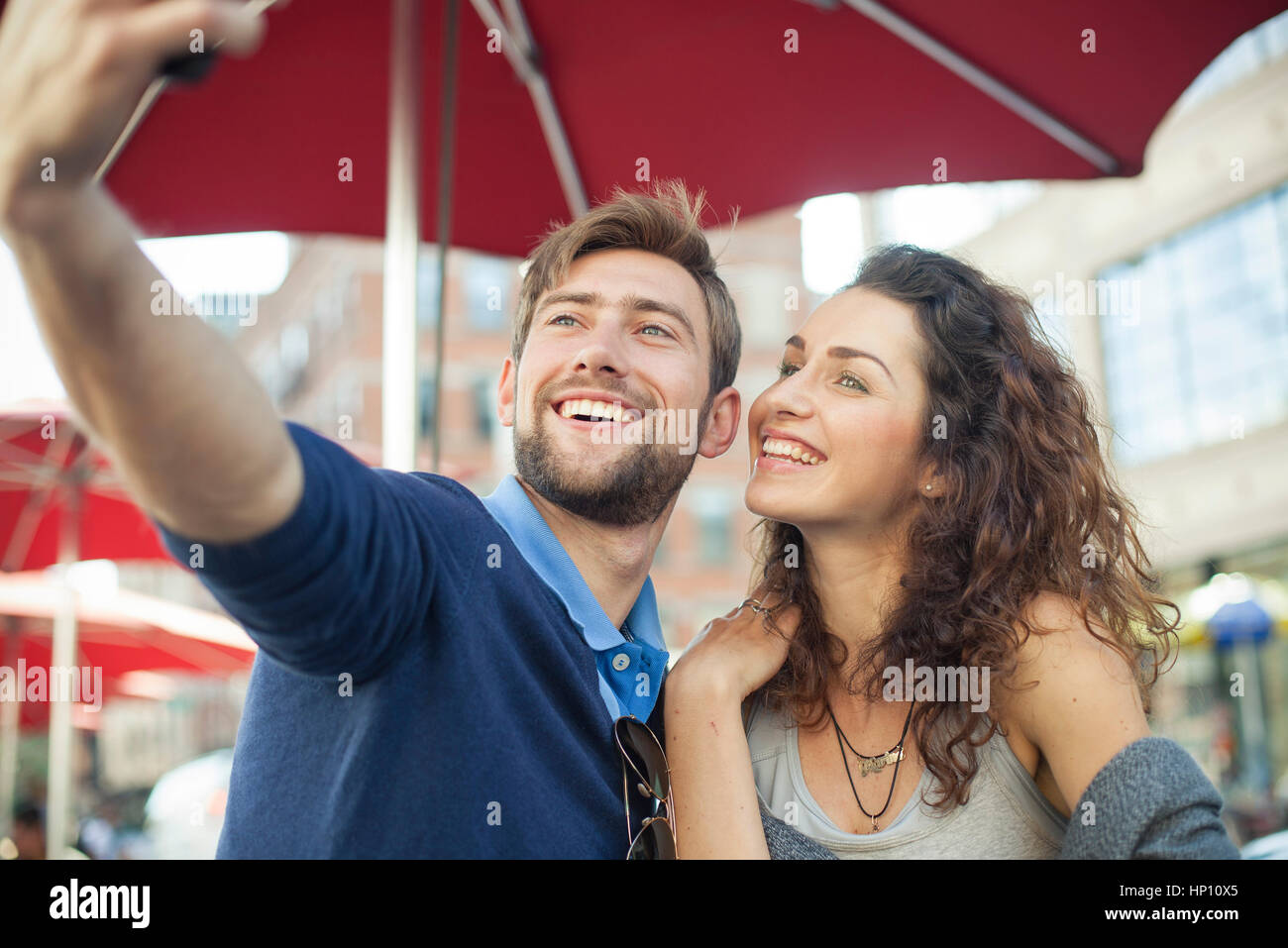 Couple posing for a selfie at an outdoor cafe Stock Photo
