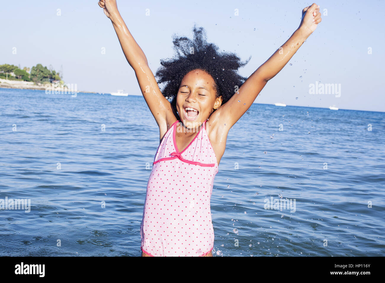 Girl in water raising arms with excitement Stock Photo