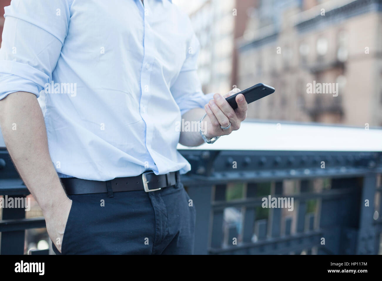Businessman holding smartphone, mid section Stock Photo