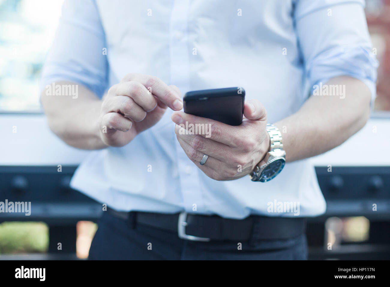 Man using smartphone, mid section Stock Photo