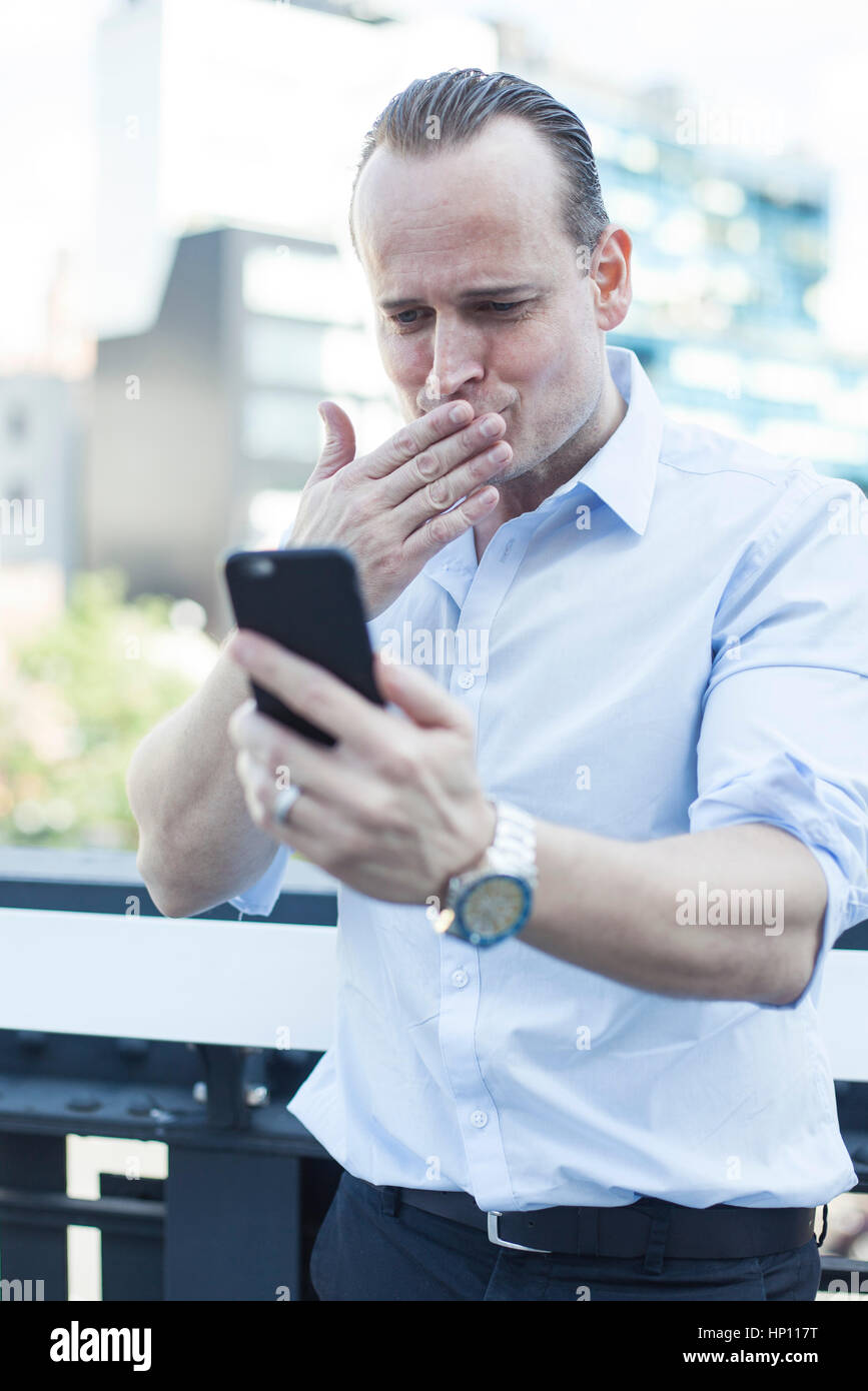 Man blowing a kiss at smartphone Stock Photo