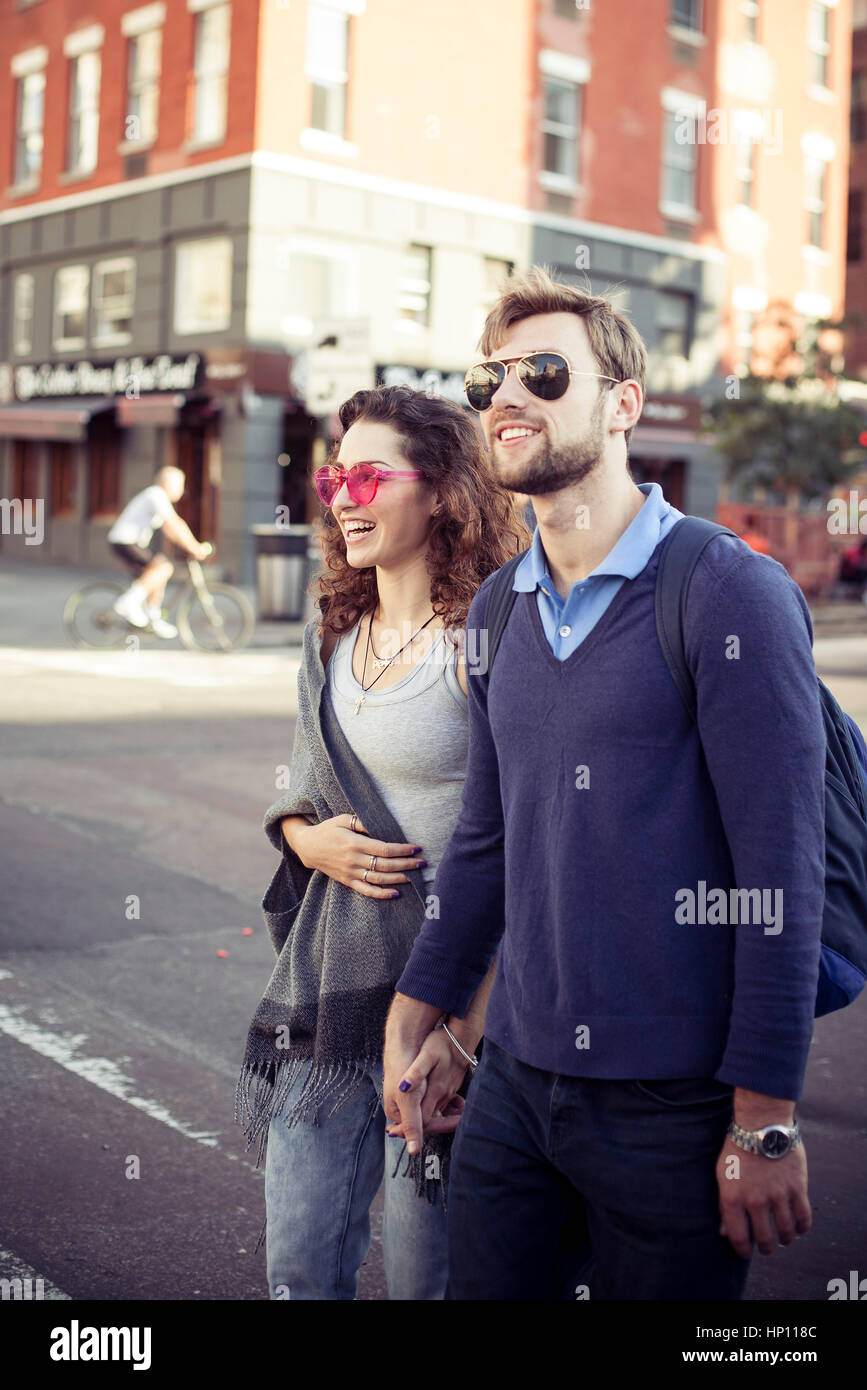 Couple crossing city street together Stock Photo