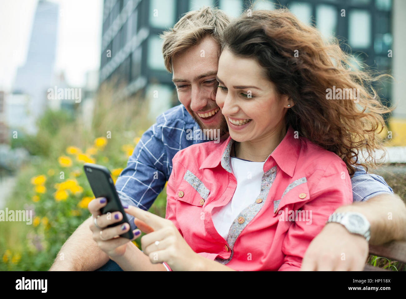 Couple relaxing together outdoors with smartphone Stock Photo