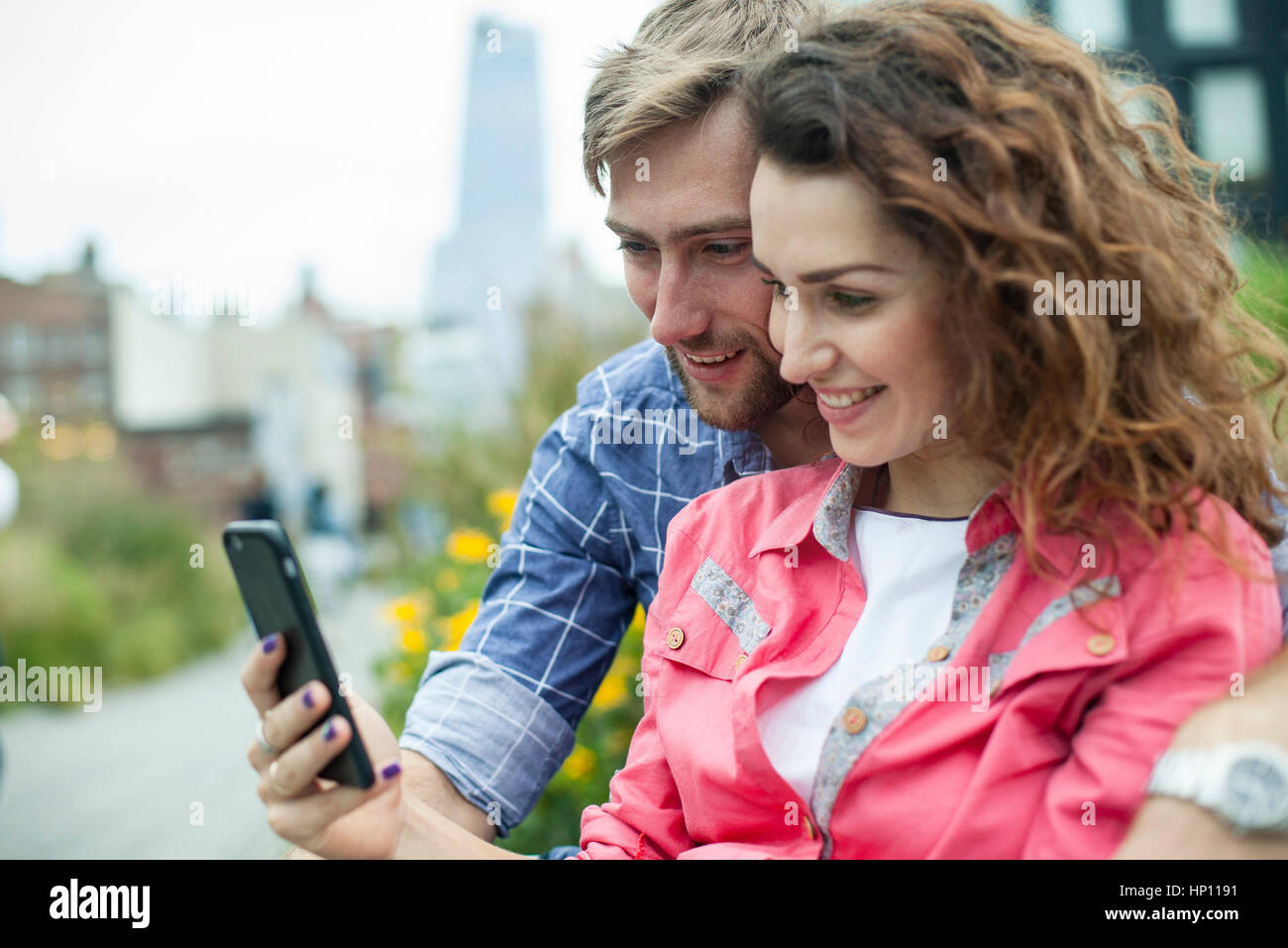 Couple looking at smartphone together outdoors Stock Photo