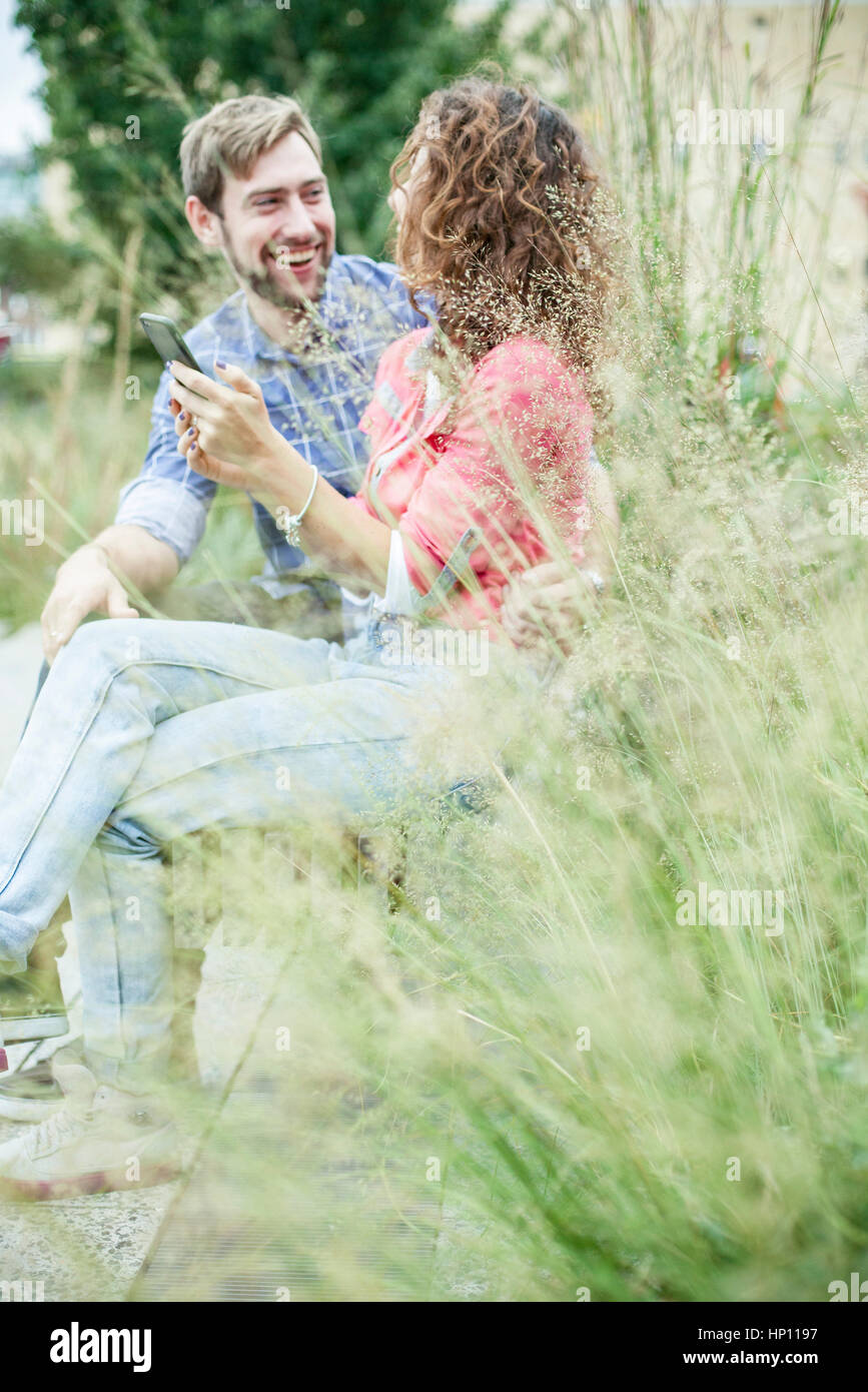 Couple relaxing together in park Stock Photo