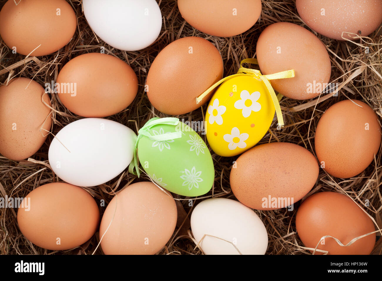 Easter eggs in straw nest. Top view Stock Photo - Alamy