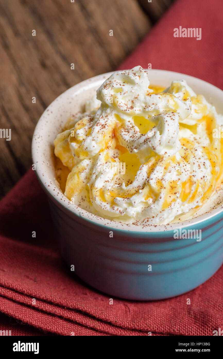 a cup of whipped cream with caramel on wooden table Stock Photo - Alamy