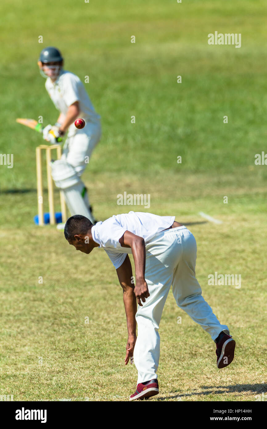 Cricket bowler bowling ball at batsman unidentified game action