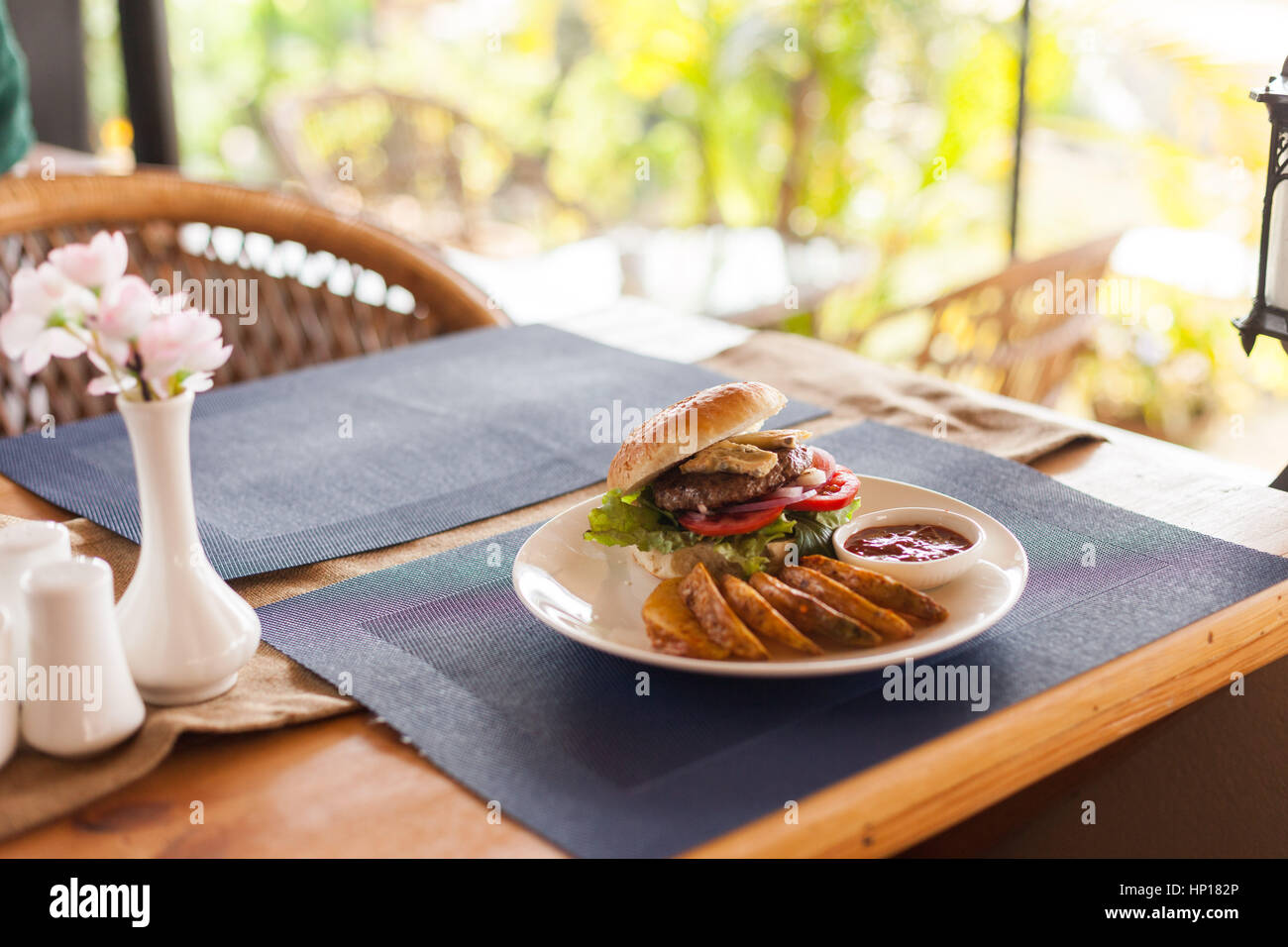 A Bleu (Blue) cheese hamburger with fries and barbecue sauce on a cafe