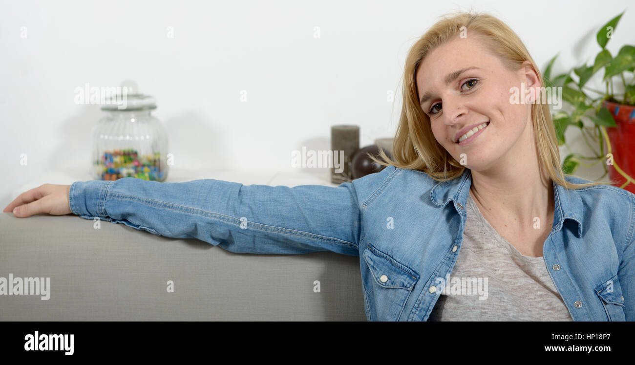 beautiful young blonde woman relaxing on sofa Stock Photo - Alamy