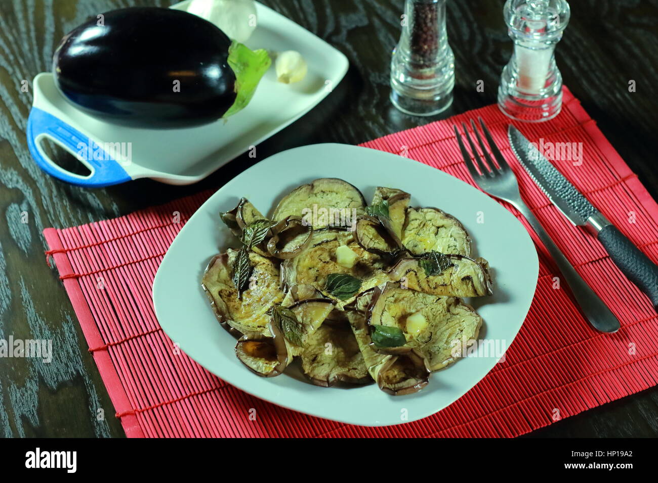 Grilled aubergine (eggplant) in olive oil and vinegar in white dish on