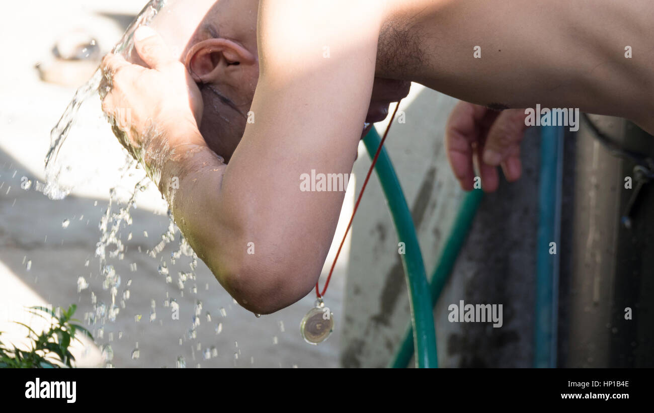 Lampang, Thailand - July 18, 2016: man who will become buddhism monk washing his head after shaving in ordination ceremony at Bunyanupab temple in Lam Stock Photo