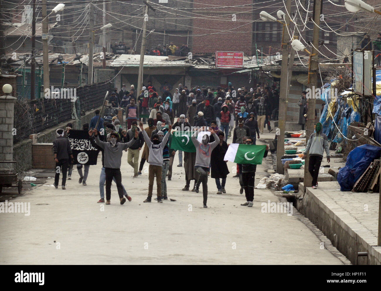 Srinagar, Indian Administered Kashmir. 17th February 2017.Masked holds pakistani flags  during the protest at grand mosque after friday prayers .Expressing disappointment over the remarks of the Army Chief General Bipin Rawat.against civilians who indulge in stone pelting during counterinsurgency operations in Kashmir would be treated as anti-nationals and dealt with accordingly.Recently in Bandipora, stone-pelters attacked soldiers when they were about to launch an operation against terrorists holed up in a house. Credit: sofi suhail/Alamy Live News Stock Photo