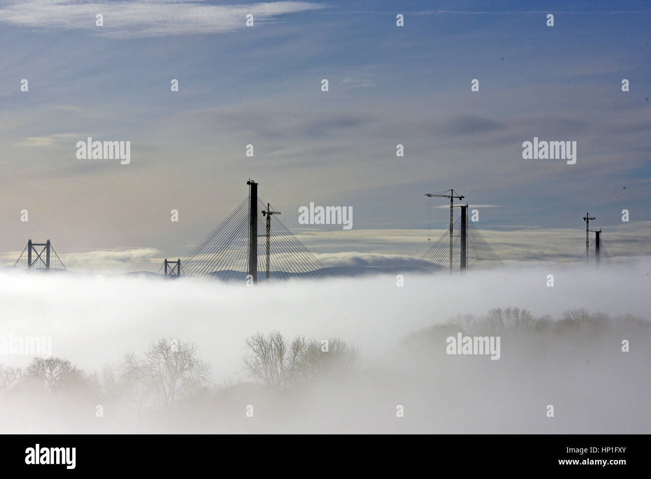 Inverkeithing, Scotland, UK. 17th February, 2017. The towers of the new Queensferry Crossing bridge across the Forth Estuary rise out of the morning mist, with the towers of the existing road bridge in the background, Credit: Ken Jack/Alamy Live News Stock Photo