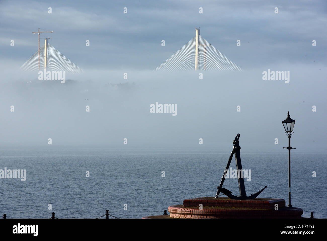 Inverkeithing, Scotland, UK. 17th February, 2017. The towers of the new Queensferry Crossing bridge across the Forth Estuary rise out of the morning mist, viewed from the seafront at St David's Harbour, Dalgety Bay, Credit: Ken Jack/Alamy Live News Stock Photo