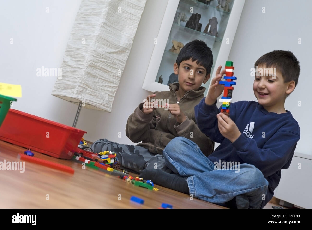 Model release , Zwei Buben, 8 Jahre, sitzen am Fussboden und spielen miteinander - two boys playing together Stock Photo