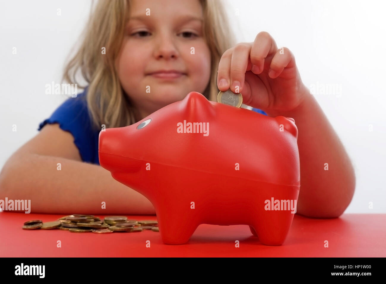 Model release , Maedchen, 8 Jahre, fuettert Sparschwein - girl with piggy bank Stock Photo